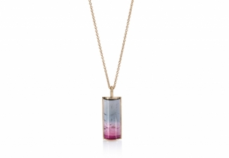 A stunning bi-colour tourmaline half barrel cabochon  set in 18ct gold with an 18ct chain and clasp
